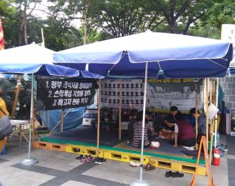 RSCJ visitant la tente des manifestations des travailleurs de Sangyong Motor dans le centre ville de Séoul. Les enseignes disent:&nbsp;

1) Rétablissement de l'honneur et excuses officielles du gouvernement ;

2) Dommages et intérêts et diminution du travail sous pression ;

3) Pouvoir de licenciement
