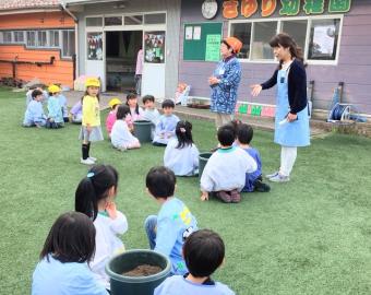 Enfants victimes du tremblement de terre dans le nouveau jardin d'enfants catholique de Sayuri plantant des graines de tomates.

